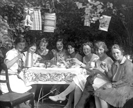 Eight women at a coffee party in the garden