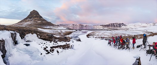 Many photographers photograph Mount Kirkjufell with frozen waterfall Kirkjufellfoss