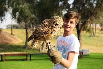 Youth stops Eagle Owl at Falconer Show at Al Wadi Desert Hotel