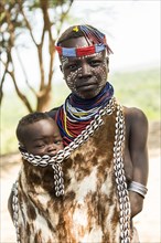 Young woman with toddler in traditional clothes made of goatskin