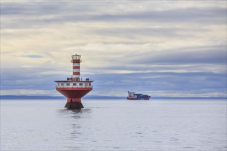 Lighthouse Phare du Haut-Fond Prince in Saint Lawrence River with freighter in the back
