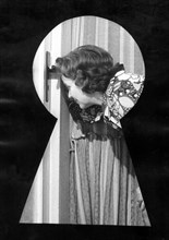 Woman looking through a keyhole