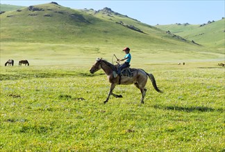 Kyrgyz boy riding his horse