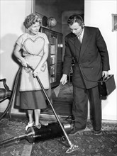 Representative and housewife with vacuum cleaner
