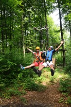 Couple in the high wire park of the forest adventure center and climbing forest Riegling