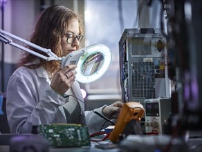 Technician with white lab coat with a measuring device in an electronics laboratory
