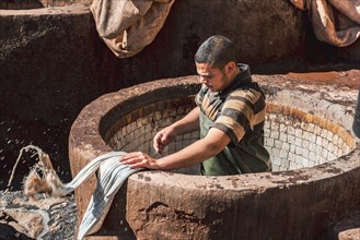 Worker dyeing leather