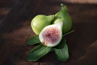 Organically grown freshly picked ripe Kadota figs on a fig leaf