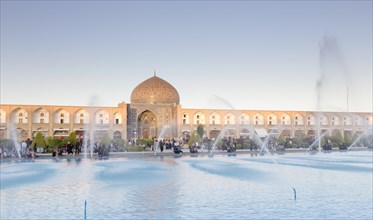 Dome of Lotfollah mosque and fountains in the pool at dusk