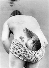 Man with fish in swimsuit ca. 1970s