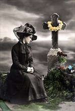 Widow mourns in front of a grave on the cemetery