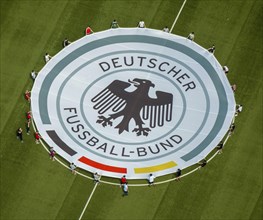 Young football players with rolled out banner with emblem German Football Association