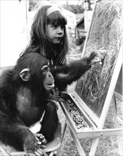 Chimpanzee with girls on blackboard
