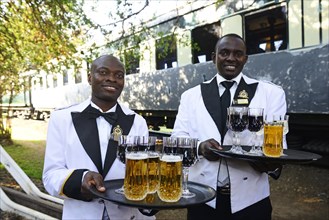 Service staff with welcome drinks in front of the luxury train