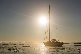 Sailing ship between ice floes in the fjord
