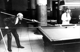 Man playing with long cue billiard