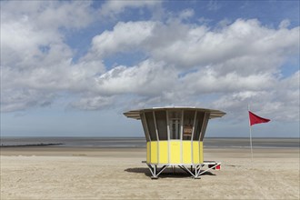 Sandy beach with modern beach guard hut