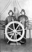 Woman and man play sailors on the steering wheel