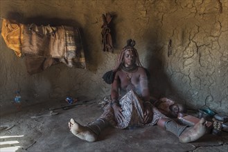 Woman of the Ovahimba or Himba people cleaning and disinfecting clothes and body