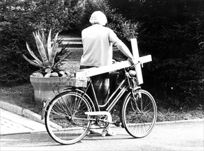 Grandma with cross on bicycle