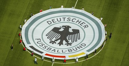 Young football players with rolled out banner with emblem German Football Association