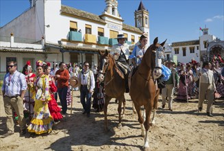 People in traditional clothes riding horses