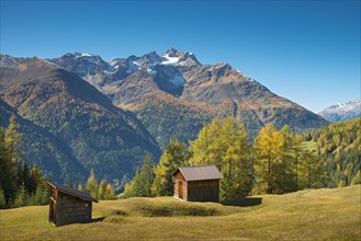 Autumnal mountain landscape with alpine huts