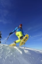 Snowshoe walker with big steps in the snow