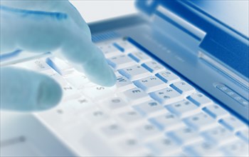 Man pressing a key on a laptop keyboard