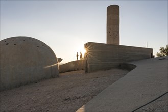 Two people standing at the concrete monument