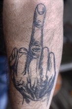 Tattoo with middle finger on arm