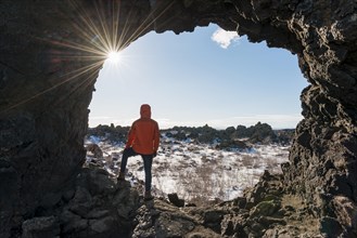 Man in a rock arch with sunbeams