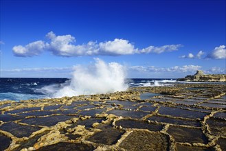 Gozo salt pans by the sea with spray