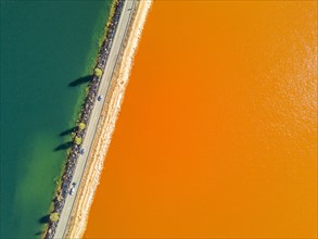 Street trough orange and blue lakes in mining region