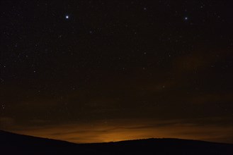 Starry night sky over a mountainous landscape near La Pobla de Segur