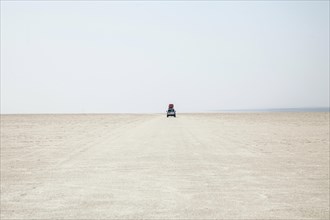 Off-road vehicle drives through the salt desert of Dallol