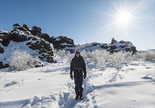 Man on hiking trail in snow in sunshine