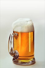 Light beer in a beer mug with a whitecap