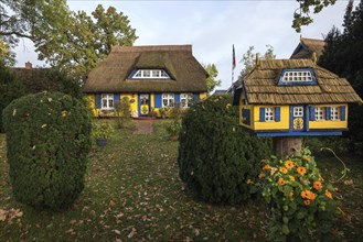 Typical yellow thatched-roof house with bird house