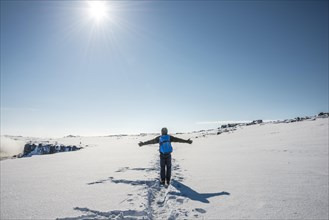 Young man walks through snowy countryside