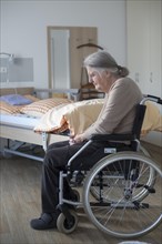 Demented Senior in a wheelchair alone in her room in a nursing home