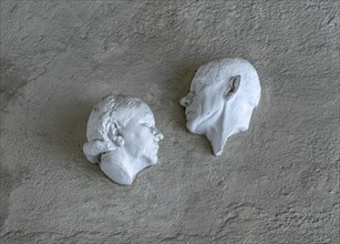 Plaster busts of Liesl Karlstadt and Karl Valentin over the entrance of the Karl Valentin Musaum