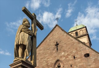 Statue on top of Emperor Constantin Fountain in front of Sainte Croix church in Kaysersberg