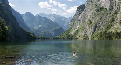 Young man is swimming in lake Obersee
