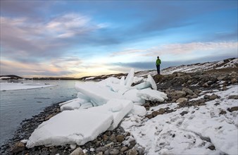 Hiker stands near ice floes