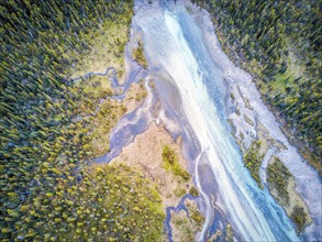 Aerial view of Bow river tributary in forest of Rockies Mountains
