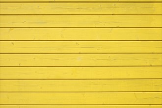 Wooden wall of horizontally arranged yellow painted boards