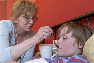 Mother takes care of sick son in bed