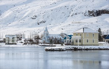 View of the blue church Seyoisfjaroarkirkja in the village Seyoisfjorour with snow