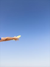 Man catching a frisbee against blue sky